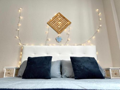 a bedroom with a bed with lights above it at Casa Tortuga 1era linea de playa in Alcalá