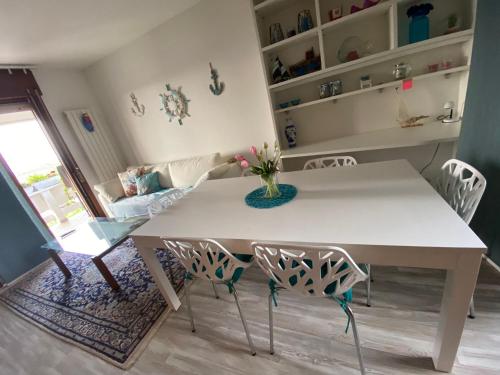 un tavolo bianco e sedie in soggiorno di Sisters'House a Lido