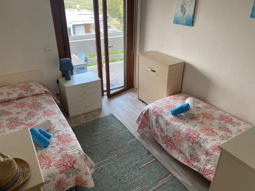 a small bedroom with two beds and a window at Sisters'House in Lido