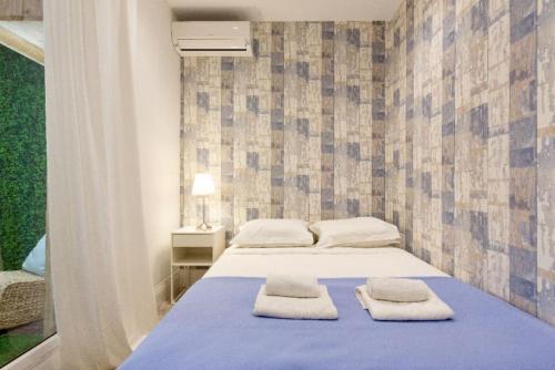 1 dormitorio con 1 cama con 2 toallas en Beach Hut * Green oasis with private patio 10 min to Palais & beaches * Pet Friendly, en Cannes