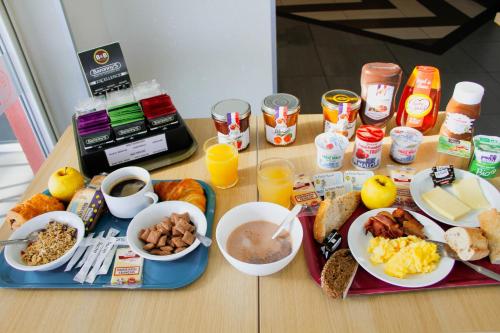 a table with breakfast foods and drinks on it at B&B HOTEL Montélimar Sud in Montélimar