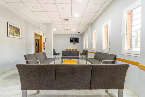 a waiting room with chairs and a table at Albergue Inturjoven Sevilla in Seville