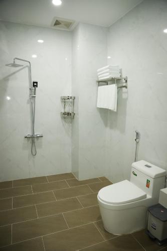 a white bathroom with a toilet and a shower at Le Phan Hotel in Tây Ninh