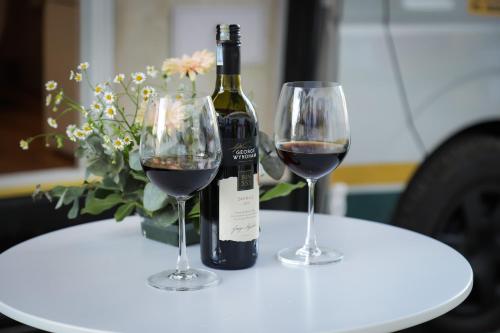 a bottle of wine and two glasses on a table at Le Phan Hotel in Tây Ninh