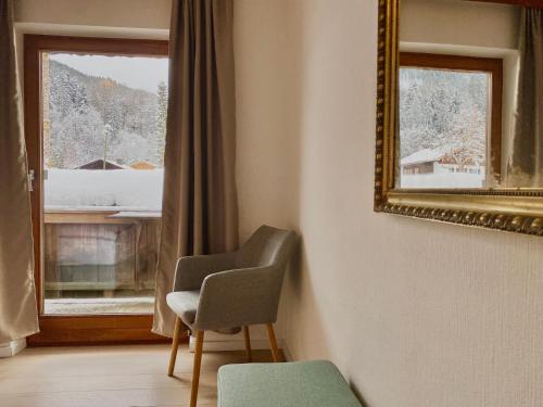 a room with a chair and a mirror and a window at Apartmenthaus am Tegernsee - Studios mit Küchenzeile und mit Bus erreichbar in Bad Wiessee