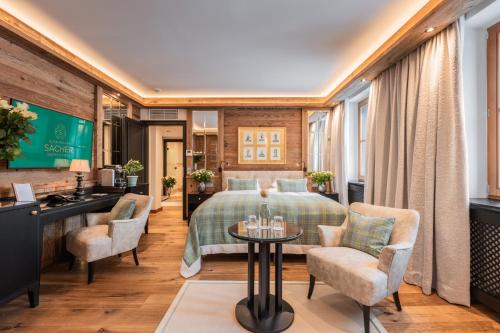 a hotel room with a bed and chairs at Alpin Resort Sacher in Seefeld in Tirol