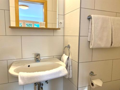 ein Bad mit einem Waschbecken, einem Fenster und Handtüchern in der Unterkunft Apartmenthaus am Tegernsee - Studios mit Küchenzeile und mit Bus erreichbar in Bad Wiessee