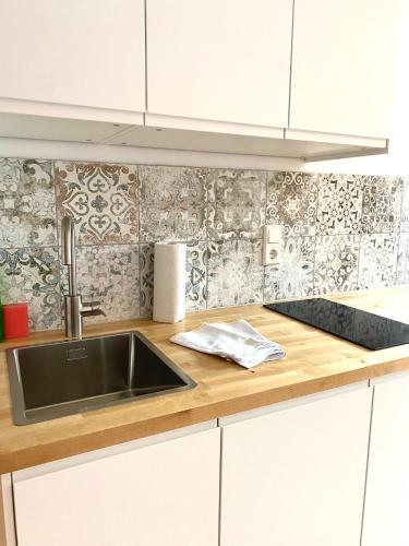 a kitchen with a sink and a wooden counter top at Apartmenthaus am Tegernsee - Studios mit Küchenzeile und mit Bus erreichbar in Bad Wiessee