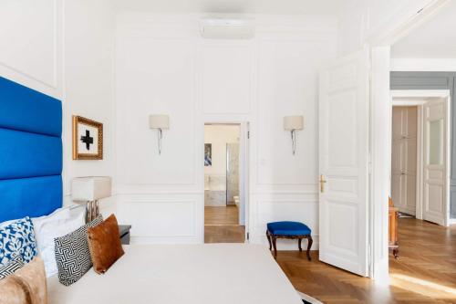 a bedroom with a white bed and a blue headboard at Broadway Residence in Budapest