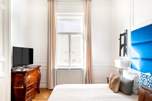 a bedroom with a bed and a tv and a window at Broadway Residence in Budapest