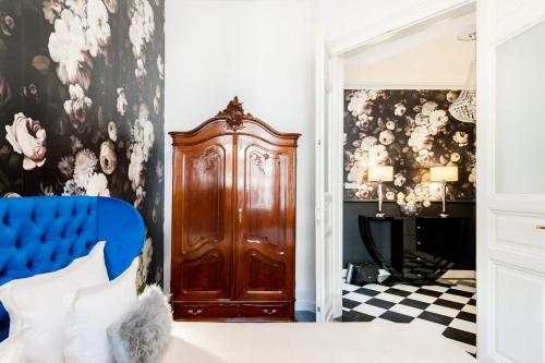 a bedroom with a blue bed and a wooden door at Broadway Residence in Budapest