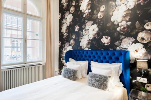 a bedroom with a blue bed with a floral wallpaper at Broadway Residence in Budapest
