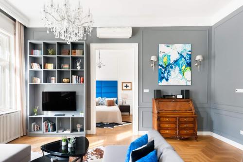 a living room with a couch and a chandelier at Broadway Residence in Budapest