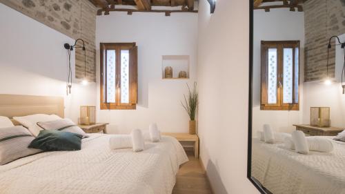 duas camas num quarto com dois espelhos em Madera y Piedra em Toledo