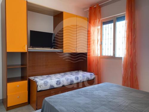 トッレ・ラピッロにあるVilla Teresa - giardino privatoのベッドルーム1室(ベッド1台、壁にテレビ付)