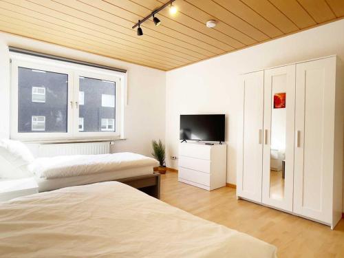 a bedroom with two beds and a flat screen tv at Cosy & Central-Apartments in Gelsenkirchen in Gelsenkirchen