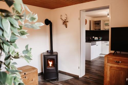 a living room with a stove in a room at Ferienwohnung am Gruberbach in Lechbruck