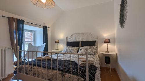 a bedroom with a bed and two lamps and a window at Le Moulin de la Motte - 12 personnes in Bellenot-sous-Pouilly