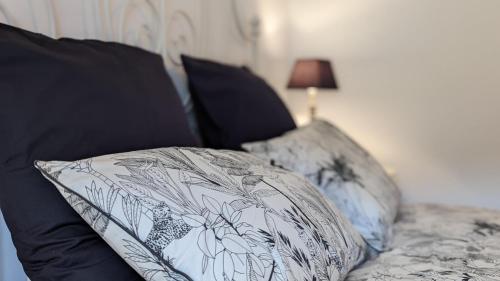 a pillow on a couch with black and white pillows at Le Moulin de la Motte - 12 personnes in Bellenot-sous-Pouilly