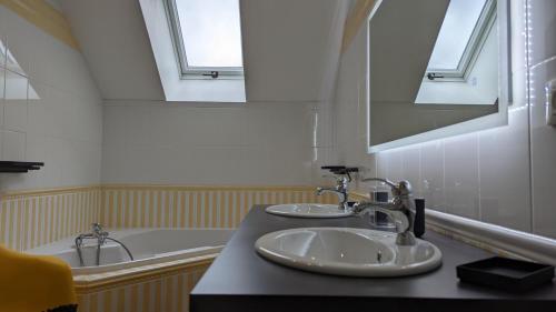 a bathroom with two sinks and a bath tub at Le Moulin de la Motte - 12 personnes in Bellenot-sous-Pouilly