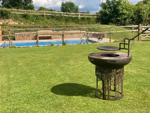a grill sitting in the middle of a yard at The Dragon's Hut with cozy logburner in Wrexham
