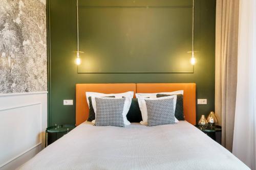 a bedroom with a bed with a green wall at Broadway Residence in Budapest
