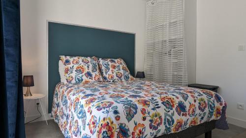 a bedroom with a bed with a colorful comforter at Le Moulin de la Motte - 12 personnes in Bellenot-sous-Pouilly