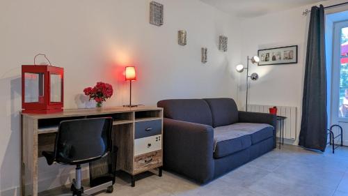 a living room with a couch and a desk and a chair at Le Moulin de la Motte - 12 personnes in Bellenot-sous-Pouilly