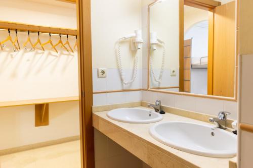 Un baño con dos lavabos y un espejo. en Albergue Inturjoven Sierra Nevada, en Sierra Nevada