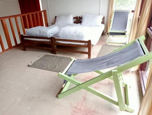 a hammock sitting in a room with a bed at THE SILVER OAK PLACE in Pithorāgarh