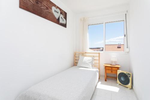 Schlafzimmer mit einem Bett und einem Fenster in der Unterkunft Home2Book Duplex El Medano Pool & Terrace in El Médano