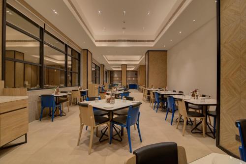 um restaurante com mesas e cadeiras e um bar em 7 Apple Hotel Nashik em Nashik