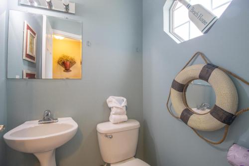 een badkamer met een wastafel, een spiegel en een toilet bij Oak Shores 95 in Biloxi