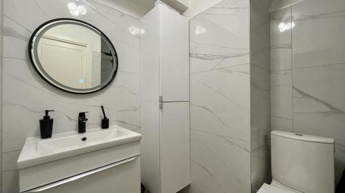 uma casa de banho branca com um lavatório e um espelho em Superbe 2 Pièces à cannes plage Festival ! em Cannes