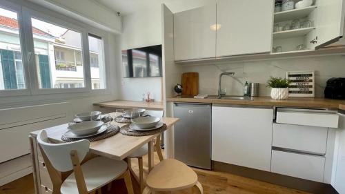 - une cuisine avec une table et de la vaisselle dans l'établissement Superbe 2 Pièces à cannes plage Festival !, à Cannes
