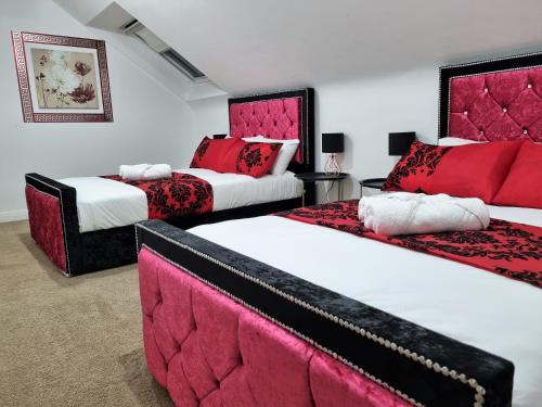 2 camas en una habitación con rojo y blanco en *F43NH* Setup for your most relaxed & Cosy stay + Free Parking + Free Fast WiFi *, en Belle Isle