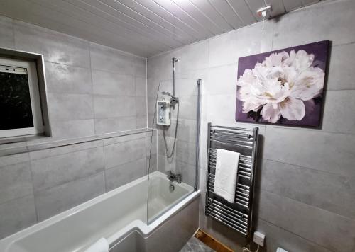 a bathroom with a shower and a painting of a flower at *F43NH* Setup for your most relaxed & Cosy stay + Free Parking + Free Fast WiFi * in Belle Isle