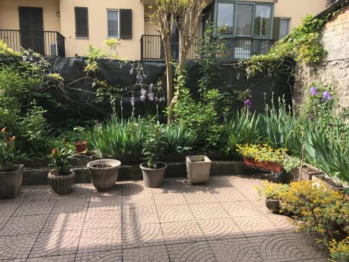 un jardín con macetas y flores en Naborre&Felice Apartment, en Lodi Vecchio