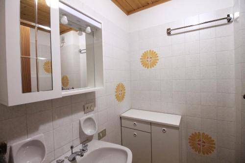 a white bathroom with a sink and a mirror at CASA PAMPEAGO - Sulle piste da sci del Latemar in Tesero