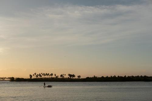 a person on a paddle board in the water at Luna Laguna in Kalpitiya