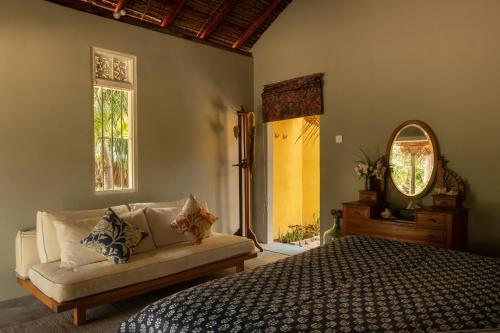 um quarto com uma cama, um sofá e um espelho em Luna Laguna em Kalpitiya