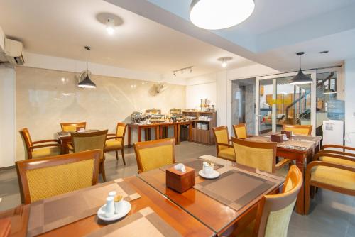 une salle à manger avec des tables et des chaises en bois dans l'établissement Hanoi Golden Sunshine Villa Hotel and Travel, à Hanoï