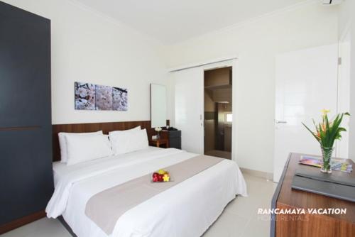 a bedroom with a large white bed with a flower on it at R Hotel Rancamaya in Bogor