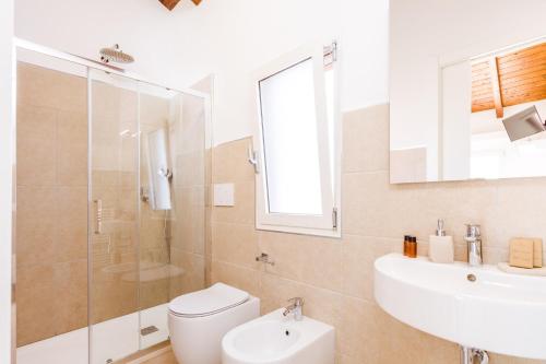 a bathroom with a toilet and a sink and a shower at La Vinia Bed&Wine Experience - Adults Only in Sassari