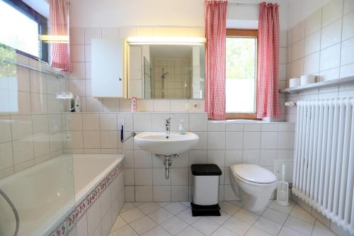 a white bathroom with a sink and a toilet at Relaxing 140m2 Holiday Home South of Munich - 25 Min to Center - Fully Equipped in Baierbrunn