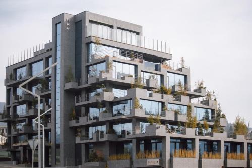 an apartment building with balconies and plants on it at HAY boutique hotel & SPA by Edem Family in Bukovel
