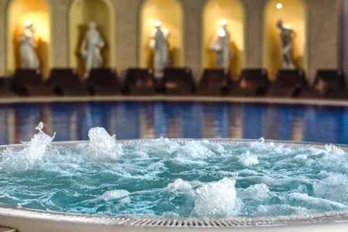 a swimming pool with water splashing in a tub at A Hoteli - Hotel Izvor in Arandjelovac