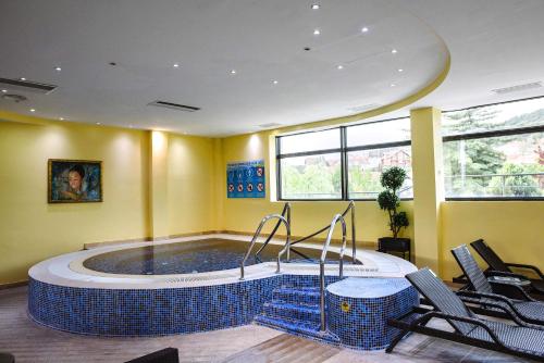 a large pool in a room with chairs around it at A Hoteli - Hotel Izvor in Arandjelovac