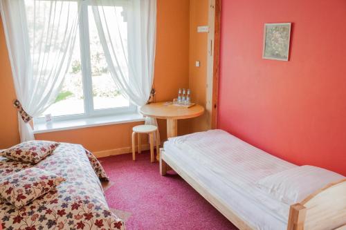 a bedroom with a bed and a table and a window at Abzali Hotel and Restaurant with self check-in in Ādaži