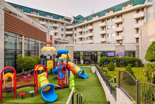 a playground in front of a building at A Hoteli - Hotel Izvor in Arandjelovac